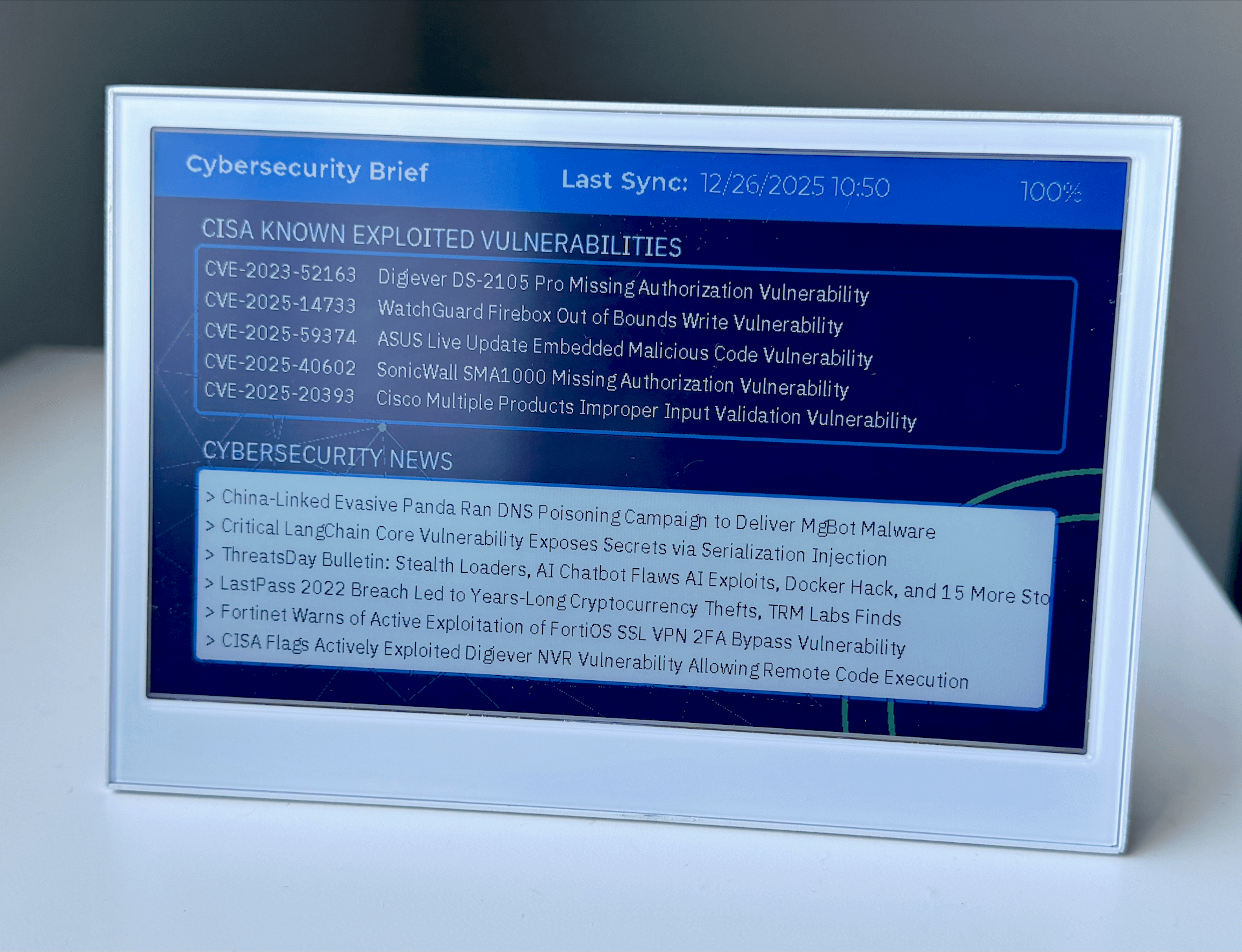 Dashboard de Ciberseguridad E-Ink mostrando vulnerabilidades CISA KEV y titulares de noticias de seguridad en un Seeed Studio reTerminal E1002